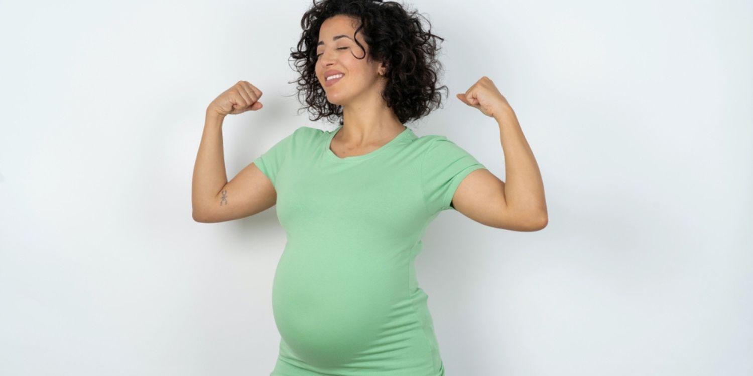 Strong,Powerful,Beautiful,Pregnant,Woman,Wearing,Green,T-shirt,Standing,Over